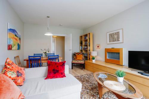 a living room with a white couch and a tv at Edinburgh Central 2-Bedroom Old Town Apartment in Edinburgh
