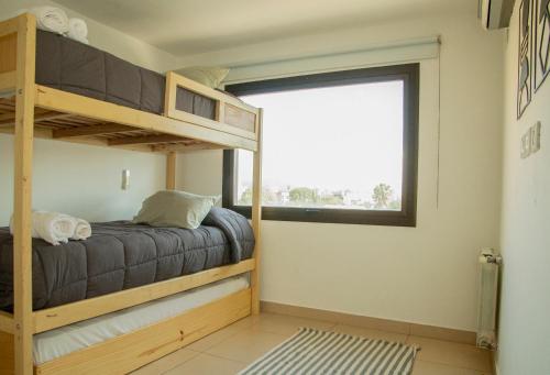 1 dormitorio con 2 literas y ventana en Leguizamon Apart en Salta