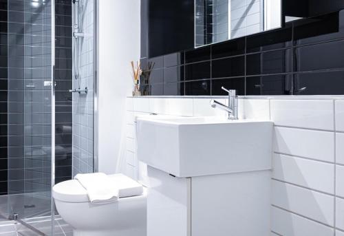 ein weißes Bad mit einem WC und einem Waschbecken in der Unterkunft Relaxing 1br1ba Apartment In Melbourne Cbd in Melbourne