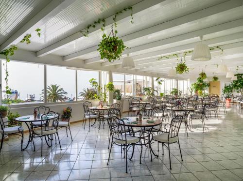 a dining room with tables and chairs and windows at Hotel Ossidiana Stromboli Center in Stromboli