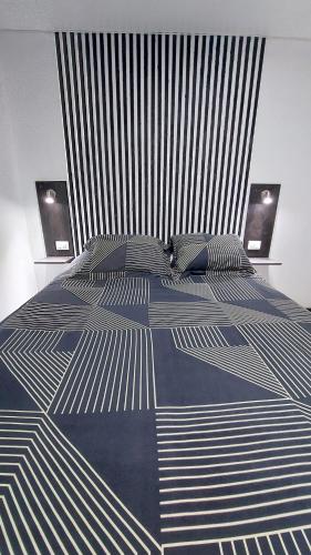 a large bed with a blue and white comforter at Pieza independiente 2 camas in Los Ángeles