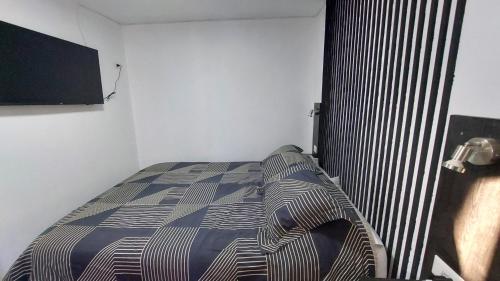 a bedroom with a bed with a striped blanket at Pieza independiente 2 camas in Los Ángeles