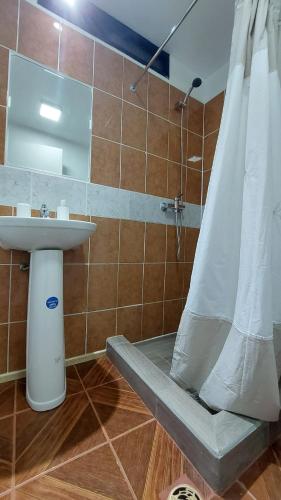 a bathroom with a sink and a shower with a shower curtain at Pieza independiente 2 camas con estacionamiento in Los Ángeles