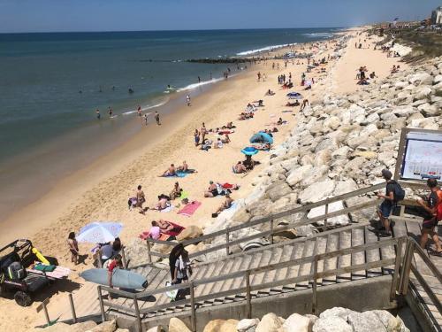 a group of people on a beach near the water at Bel appartement en pierre de 100 m2 avec cour. in Margaux