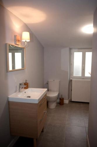 a bathroom with a sink and a toilet at Bel appartement en pierre de 100 m2 avec cour. in Margaux