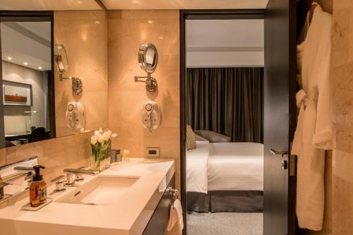 a bathroom with a sink and a bed in a room at Hotel Tamanaco Caracas in Caracas