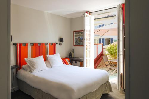 a bedroom with a large bed and a balcony at Boutique Hôtel Txoko in Saint-Jean-de-Luz