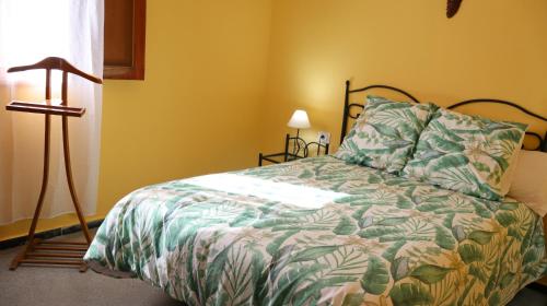 a bedroom with a bed with a green comforter at Casa rural en San Mateo in Las Palmas de Gran Canaria