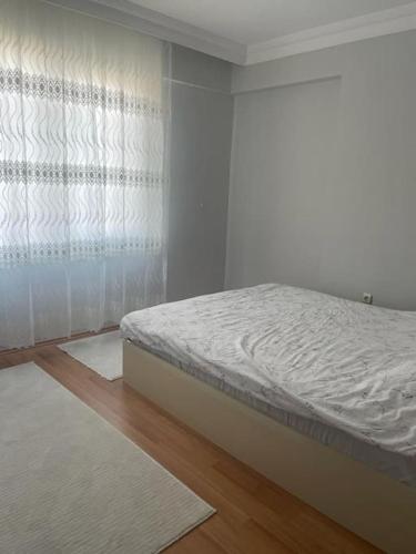 a bedroom with a bed with a curtain and a floor at Deniz ve Giresun manzaralı daire in Boztekke
