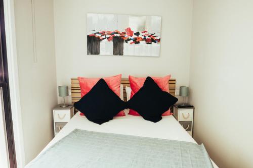 una camera da letto con un letto con cuscini rossi e neri di El Rincón del Mar a Tacoronte