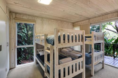 two bunk beds in a room with windows at Billa Villa in Point Lookout