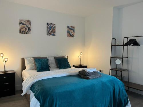 a bedroom with a bed with a blue blanket at Hemel Apartments- Tranquil Haven in Hemel Hempstead
