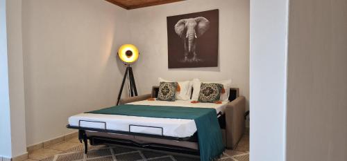 1 dormitorio con 1 cama y una foto de elefante en la pared en Casa Vista do Monte, en Povoação