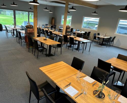une salle à manger avec des tables et des chaises en bois dans l'établissement Aarau West Swiss Quality Hotel, à Oberentfelden