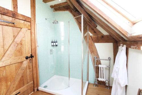 a bathroom with a shower with a glass door at Acorn Barn in Crediton