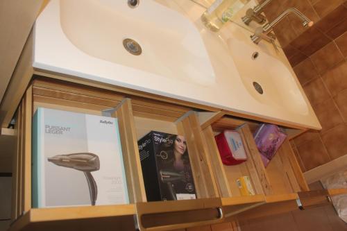 La salle de bains est pourvue d'une coiffeuse, d'un lavabo et d'un livre. dans l'établissement Whole cosy and comfy apartment, Valmeinier 1500, with terrace, à Valmeinier