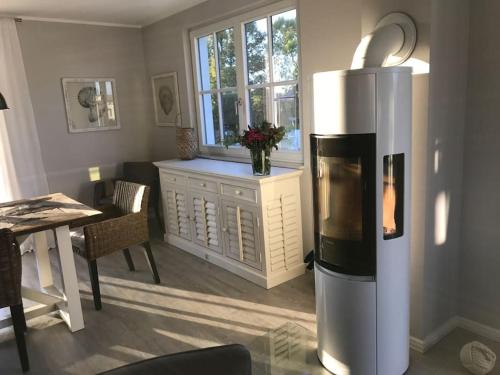 グロース・シュヴァンセにあるStilvolles Reetdachhaus Coastline an der Ostseeのキッチン(冷蔵庫、テーブル付)、窓が備わります。