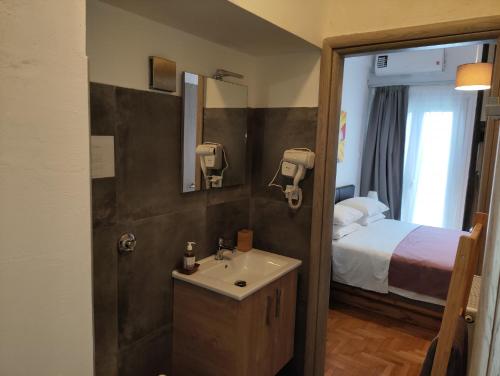 a bathroom with a sink and a bed at Ulysses Apartments Acropolis in Athens