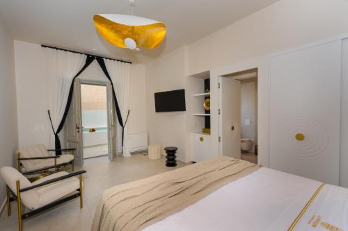 a bedroom with a bed and a chair and a mirror at La Madeleine Oia in Oia
