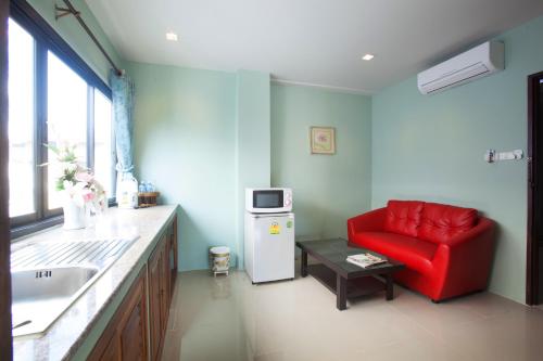 a living room with a red chair and a refrigerator at The Sun Terrace in Chiang Mai