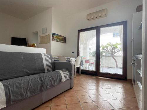 a living room with a couch and a sliding glass door at Le Residenze Blu Sardinia in La Caletta