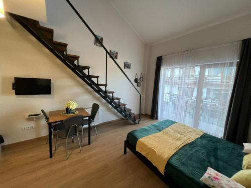 a bedroom with a bed and a table and a staircase at 7 Senses Vista 1 BD Apartment in Gudauri