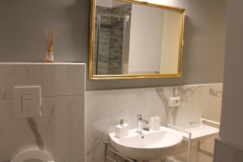 W łazience znajduje się umywalka i lustro. w obiekcie Casa Hari w mieście Salerno