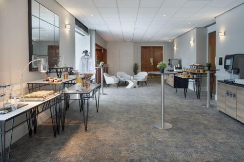 a lobby with tables and chairs in a room at Delta Hotels by Marriott Heathrow Windsor in Windsor