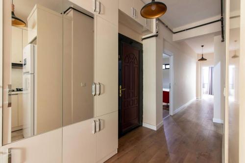 a kitchen with white cabinets and a brown door at Spacious & Trendy 3BR Urban Home w/ ACs in Istanbul