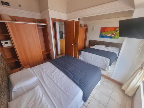 Dormitorio pequeño con 2 camas y armario en Tropical Executive Vista Maravilhosa, en Manaus