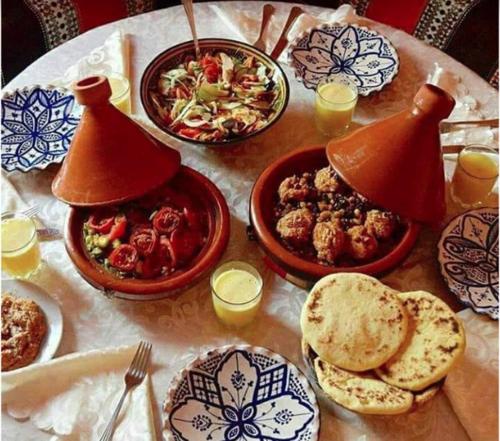 una mesa con platos de comida y tazones de comida en Black Sand Camp en Al Mintirib