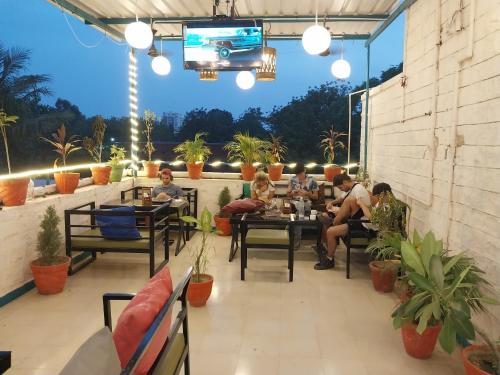 Un grupo de personas sentadas en mesas en un patio. en Blue town Hostel & Cafe, en Jodhpur