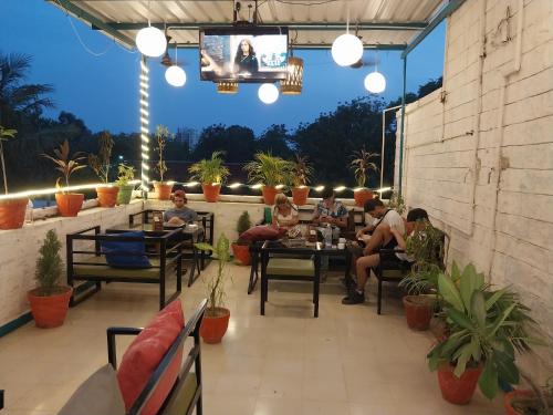 Un grupo de personas sentadas en mesas en un patio. en Blue town Hostel & Cafe, en Jodhpur