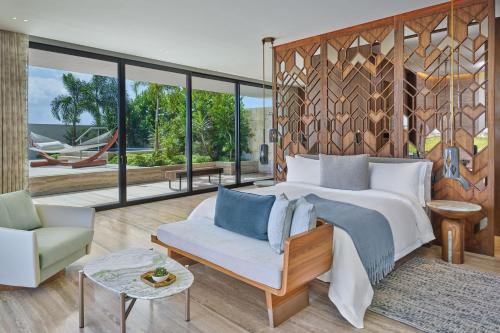 a bedroom with a bed and a couch and a chair at The St. Regis Kanai Resort, Riviera Maya in Playa del Carmen