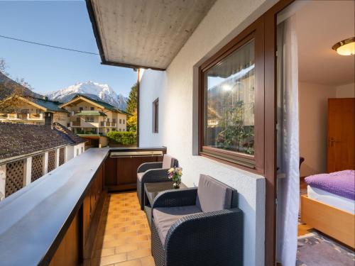 a balcony with chairs and a bed and a window at Chalet - Appartements Julitta in Mayrhofen