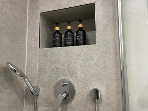 Trois bouteilles noires d'alcool sont dans une douche dans l'établissement Wohnung in Augsburg Innenstadt -Tiefgarage, à Augsbourg