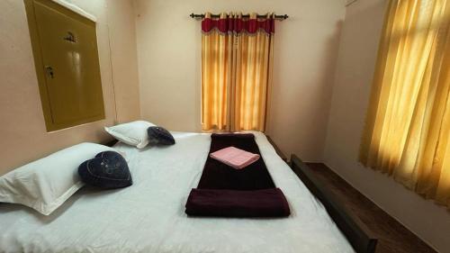 a bedroom with a bed with two towels on it at Rose villa in Meenangadi
