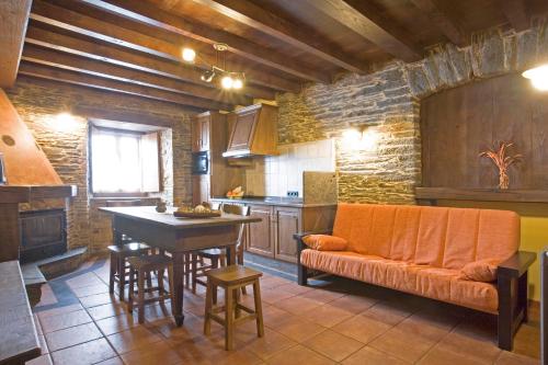 a kitchen with an orange couch and a table at Balcón de Oscos in Santa Eulalia de Oscos