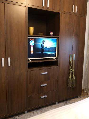een tv in een houten entertainmentcentrum met een televisie bij Adrian Home Mega in Ploieşti