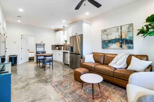 a living room with a brown couch and a kitchen at Jazz House*King Bed*Lux Matt*Coffee Bar in Lafayette