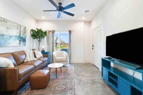 a living room with a couch and a flat screen tv at Jazz House*King Bed*Lux Matt*Coffee Bar in Lafayette