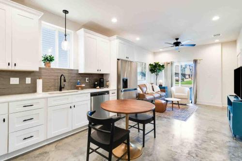 a kitchen with white cabinets and a table and a living room at Jazz House*King Bed*Lux Matt*Coffee Bar in Lafayette