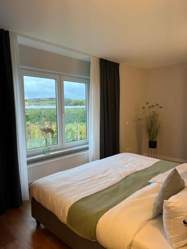a bedroom with a large bed and a large window at Vorgebirgsblick - Restaurant Biergarten Gästehaus in Bornheim