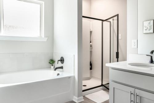 a white bathroom with a tub and a sink at Winners Paradise next to LSU in Baton Rouge