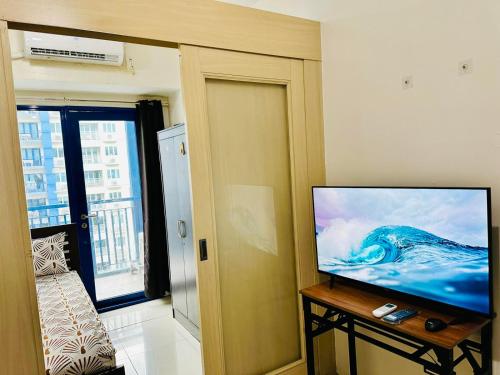 a living room with a flat screen tv on a table at Sea Residences by Jan & Val Alano in Manila
