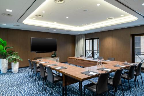 a large conference room with a large wooden table and chairs at The Den, 's-Hertogenbosch, a Tribute Portfolio Hotel in Den Bosch