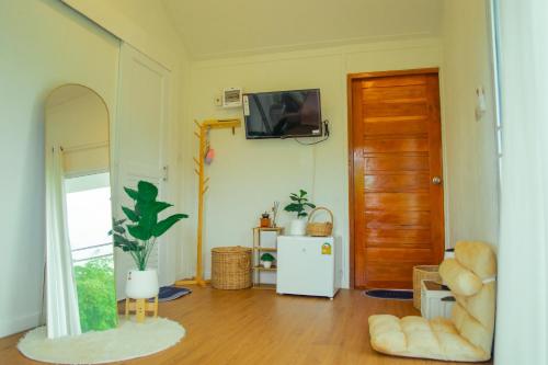 a living room with a television on a wall at Cana Garden 3 in Ban Khok