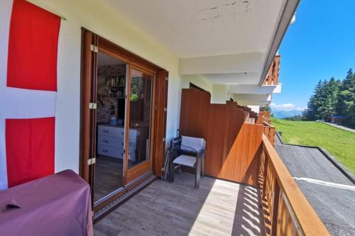 een balkon van een huis met een bureau en een stoel bij Cozy apartment "WAPITI" at the foot of the slopes in Les Déserts