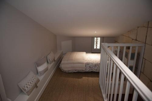 ein kleines Schlafzimmer mit einem Bett und einer Treppe in der Unterkunft bel appartement en pierre de 88 M2 charme d’antan in Margaux
