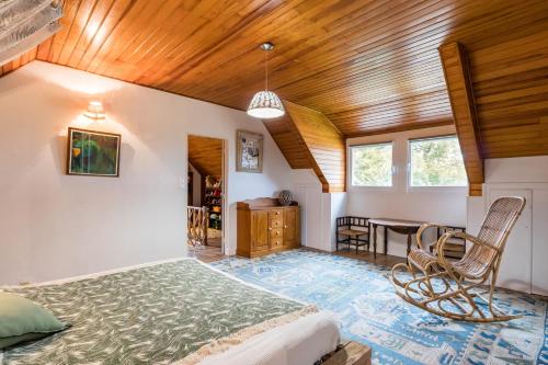 une chambre avec un lit et un plafond en bois dans l'établissement La Maison Bleue au coeur des Plages du Débarquement, à Ver-sur-Mer